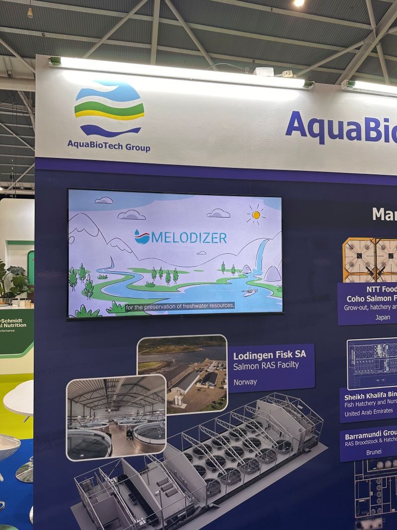 melodizer-aquabiotech-world-aquaculture-2026 AquaBioTech representative at the MEloDIZER booth during World Aquaculture 2026 in Singapore, with project brochures and dissemination materials on display.